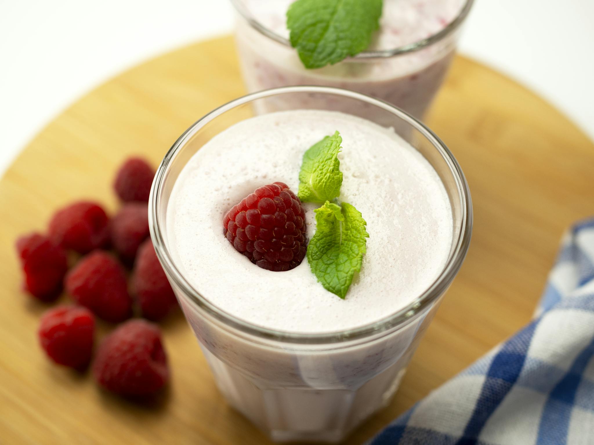 Creamy raspberry yogurt smoothie topped with fresh mint and berries, perfect for a healthy treat.